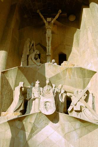 the top of a monument shows jesus on the cross, a crucifix and statues