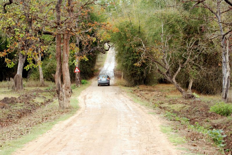 a car driving down a dirt road in the middle of nowhere