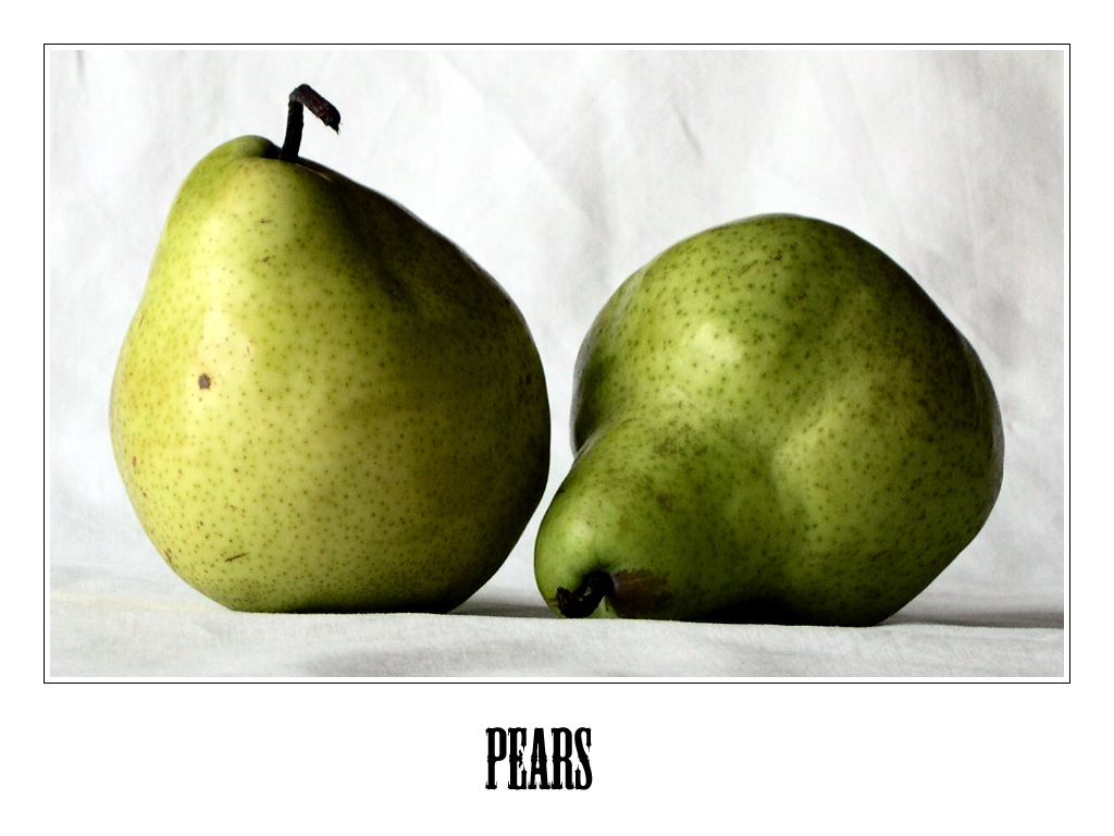 two green pears are positioned to look like they could be apples