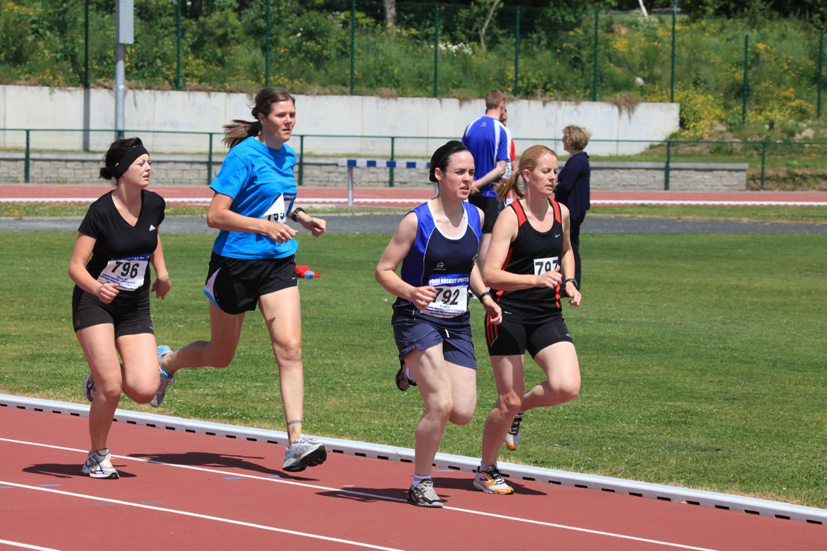 four people racing one another at an athletics event