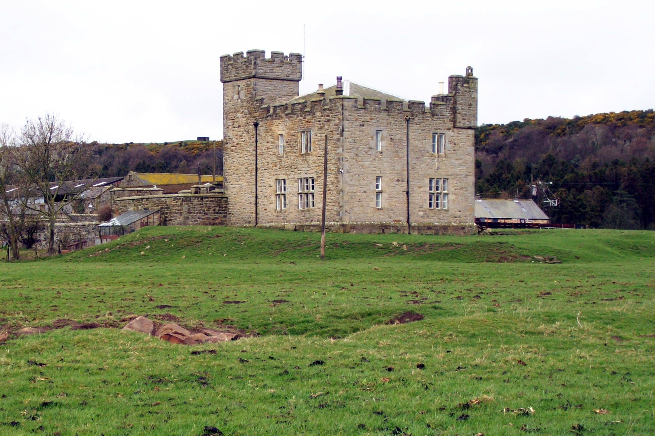 a brown and yellow stone castle sitting on top of a lush green field