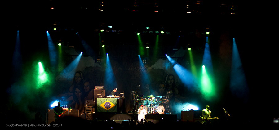 the people are on stage playing with green and blue lights