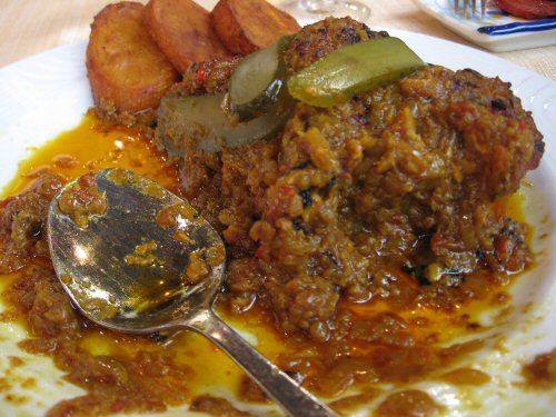 a plate full of food with a spoon next to it