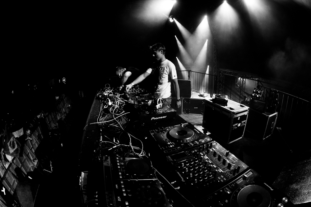 a man standing at the top of an electronic mixing desk