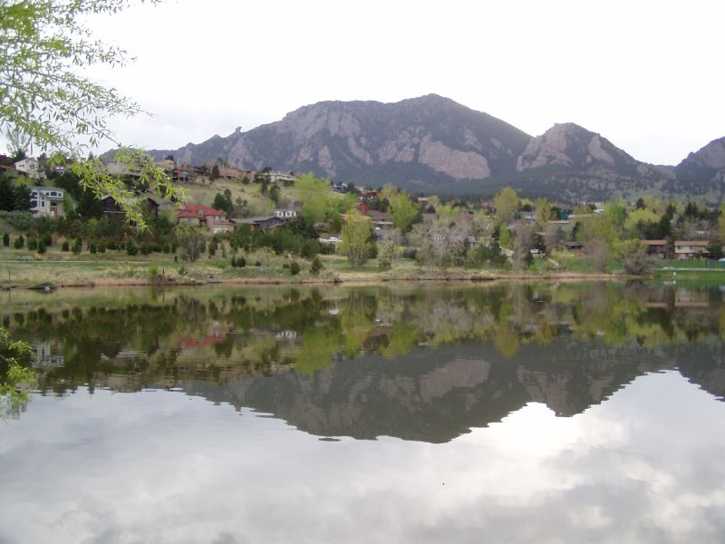 a peaceful place with the hills and trees reflected in the water