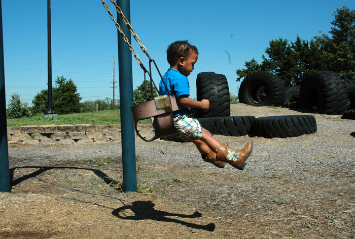 a child swinging on a tire swing in a playground