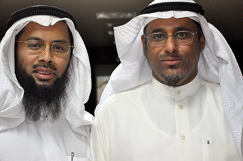 two men wearing large white head coverings posing for a picture