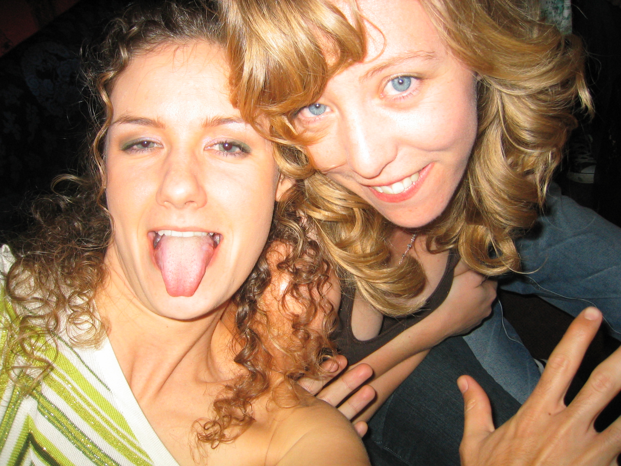 two young women pose for a picture in a darkened room