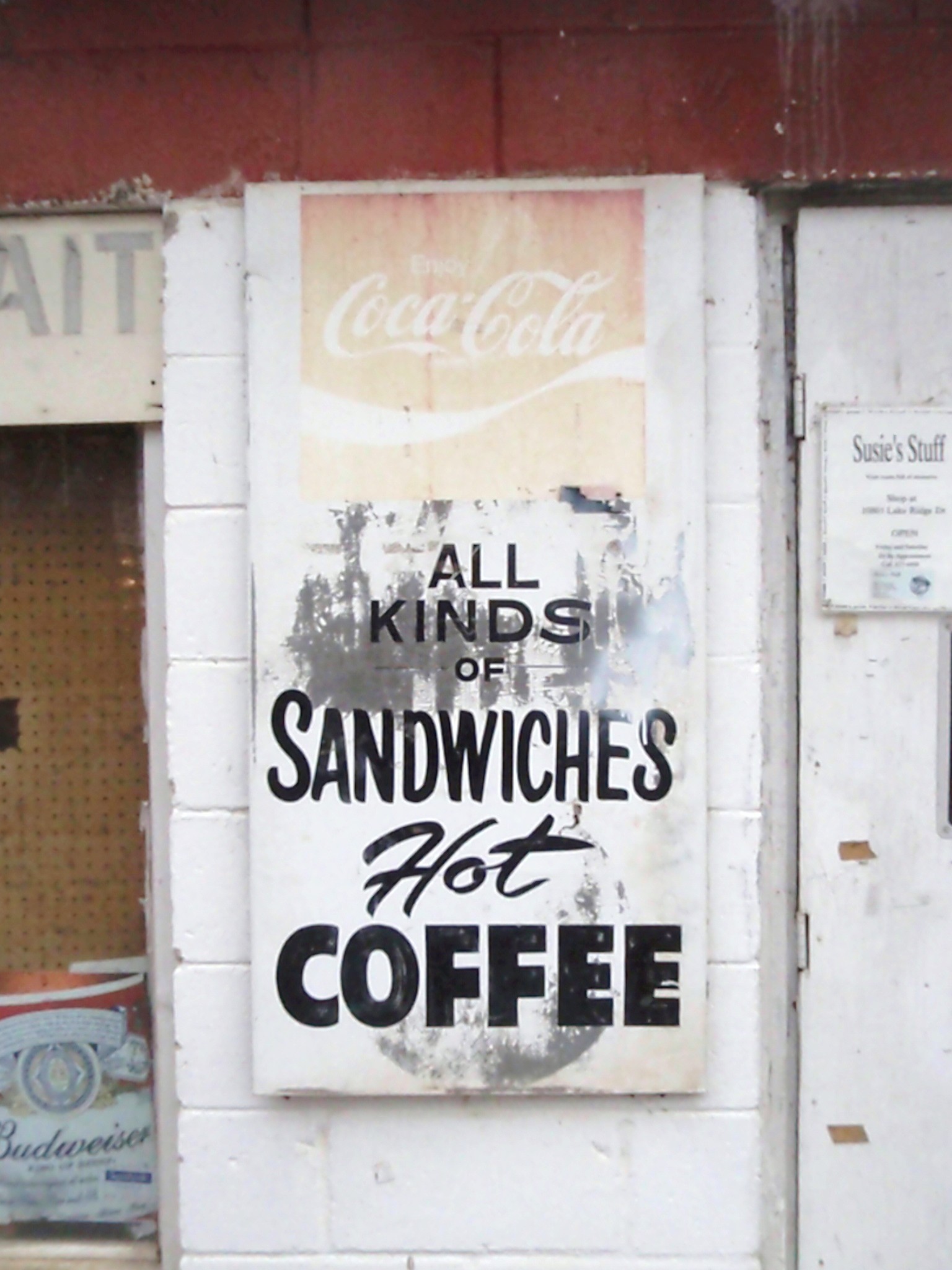 a white wall with a sign that says all kinds of sandwiches for coffee