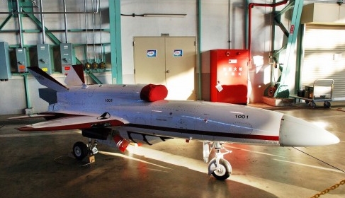 a red white and grey airplane in a garage