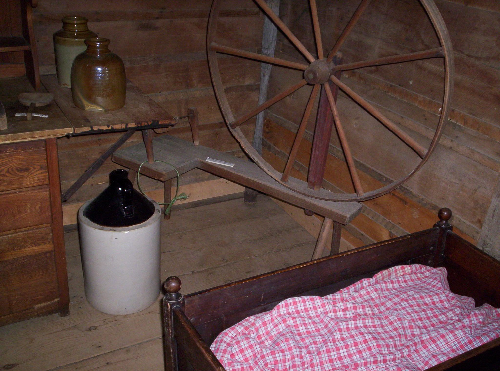 the empty bottle is near a wooden wheel and a bottle in a wagon