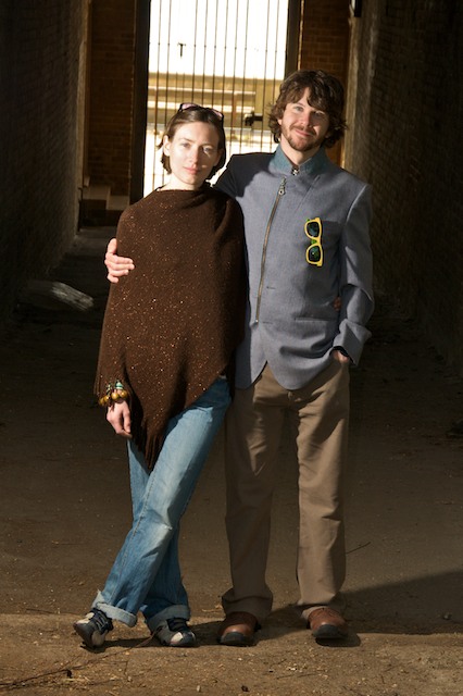 the couple is posing for the camera in an alley