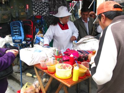 people standing in front of a vendor holding onto containers