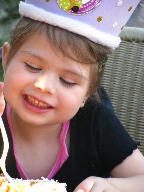 a child in purple is eating cake with a spoon