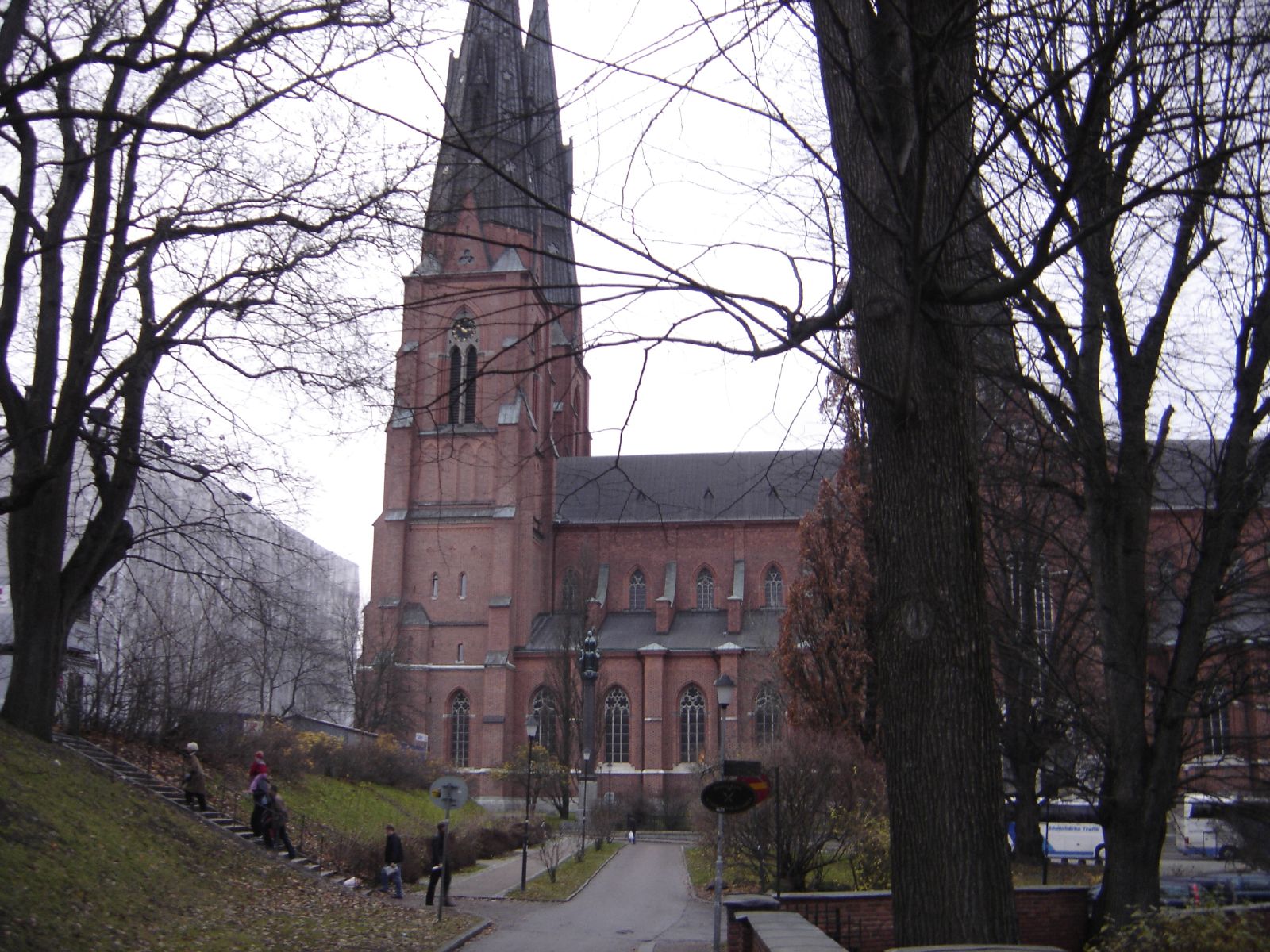 people on a path next to a tall brick church