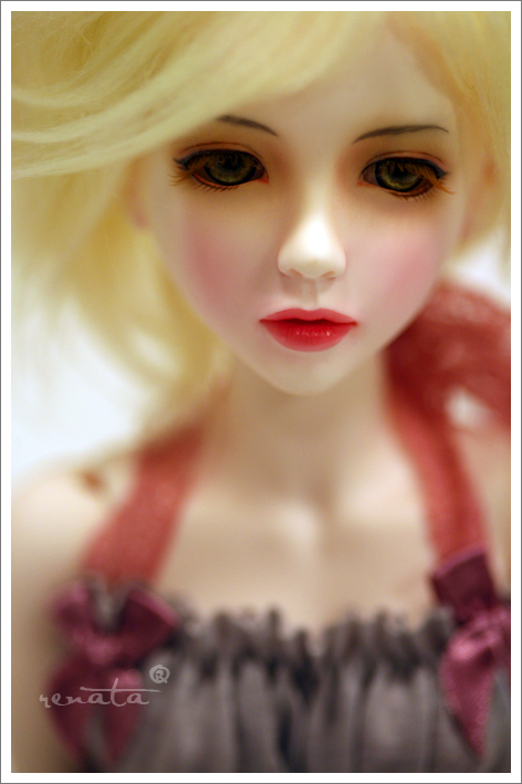 a close up of a doll with blonde hair