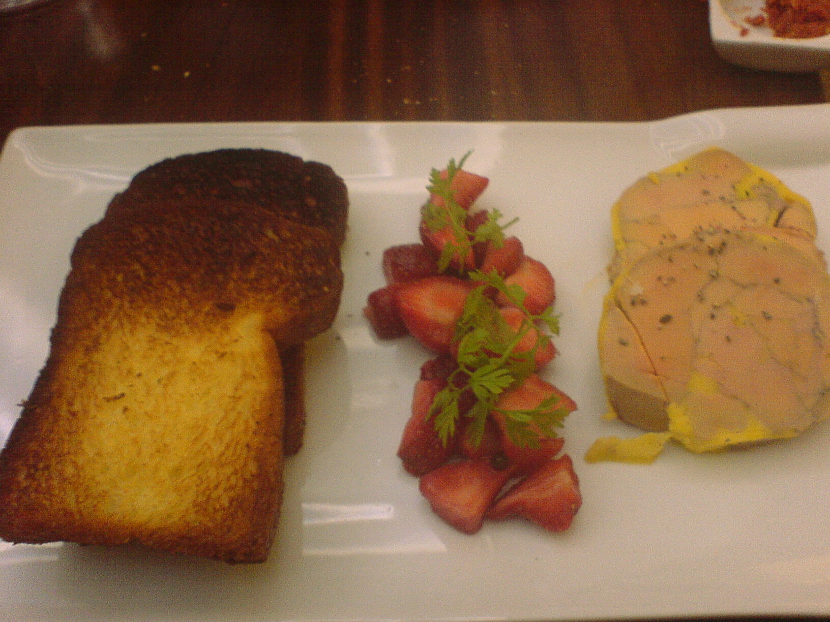 a white plate with two slices of bread and strawberries on it