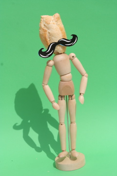 a little figurine standing with a black and white mustache on it's head