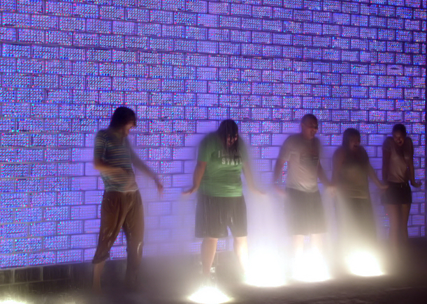 people standing on stage in front of water spraying