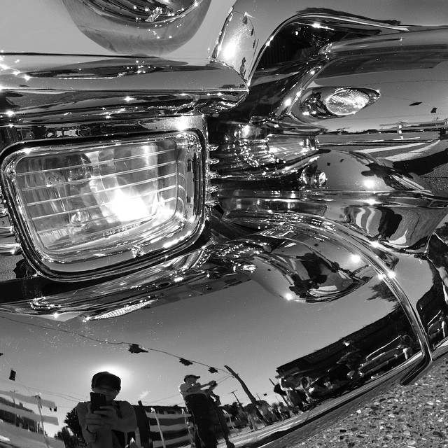 the back end of a shiny motorcycle in a black and white po