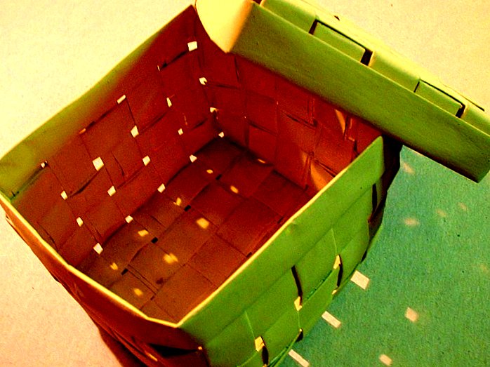 a green basket with an odd shaped handle and a bent section on top