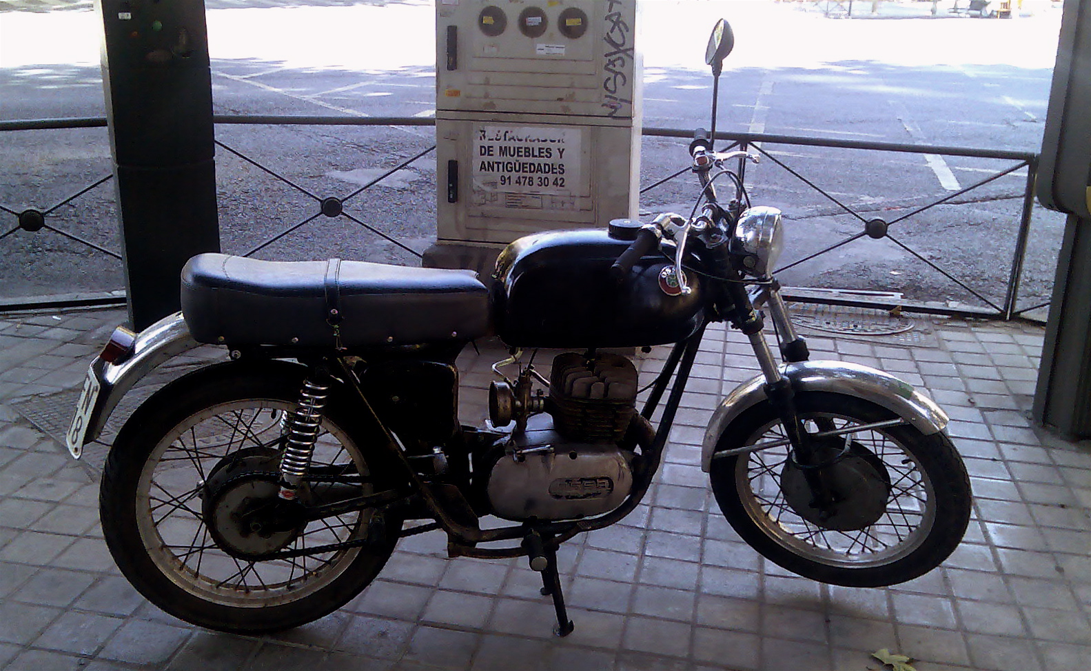 a motorcycle parked by a fence on the street