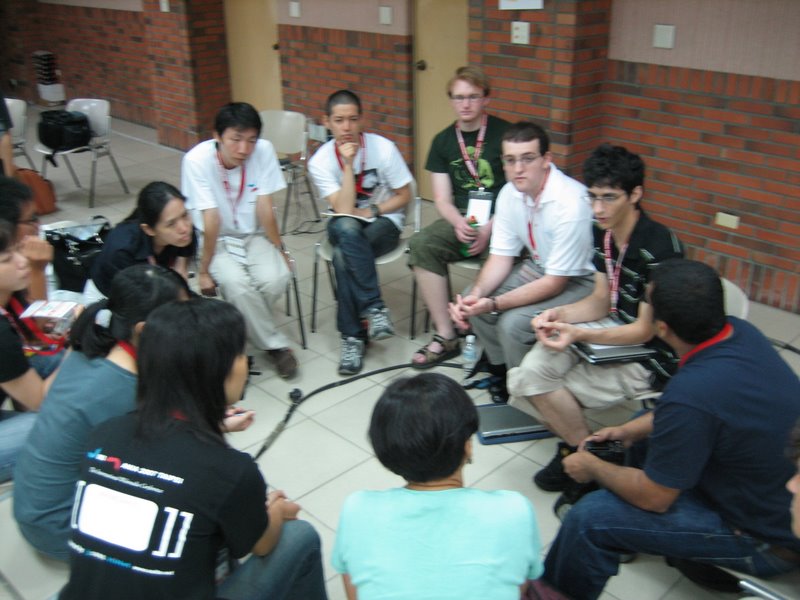 a group of people sitting next to each other on top of a tiled floor