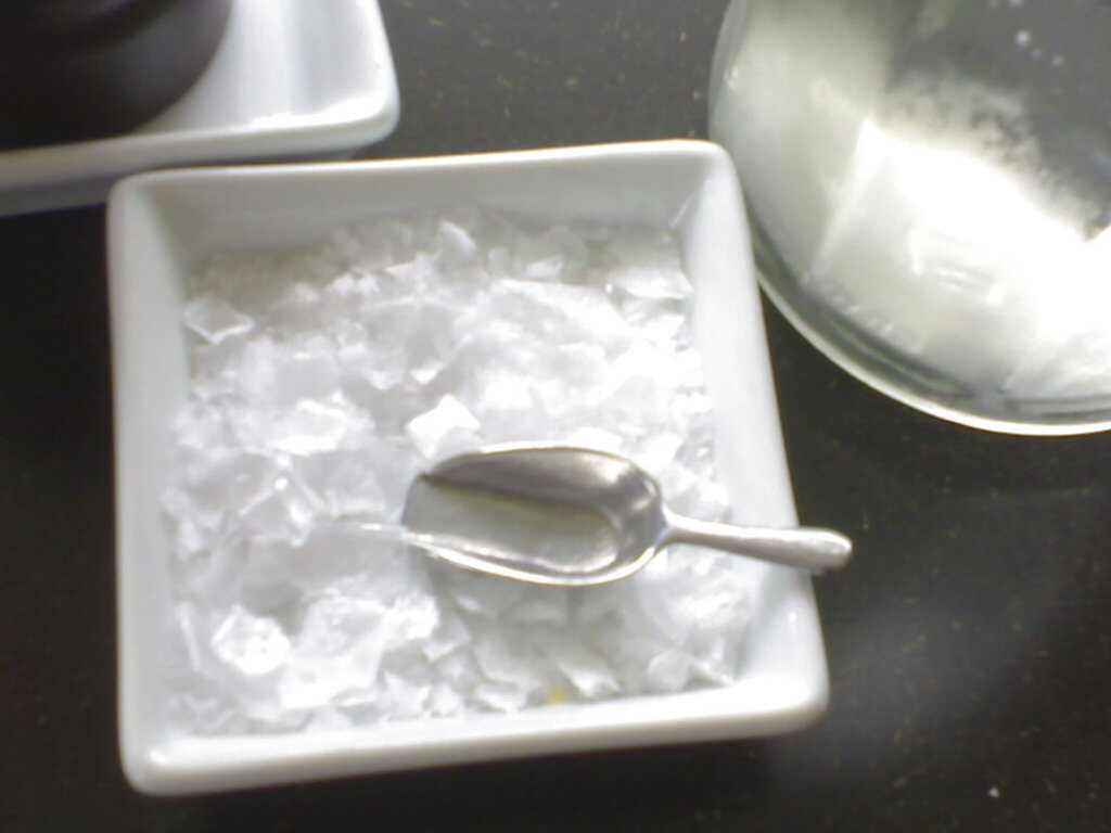 a spoon sitting on top of ice and an empty bowl