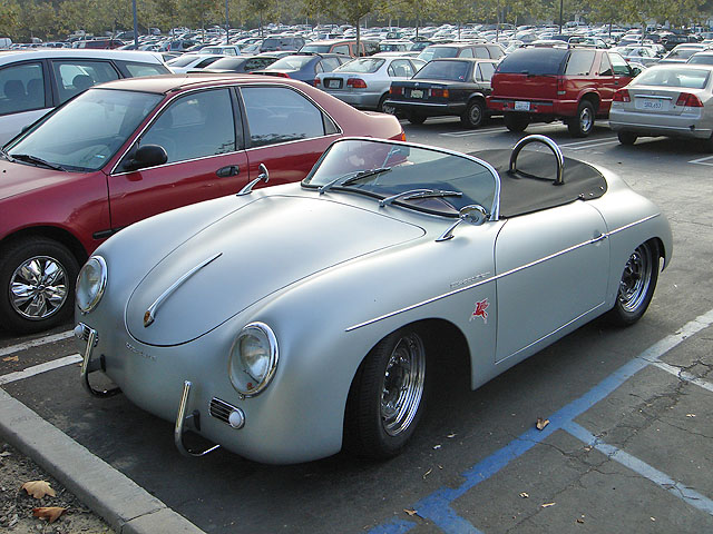 a silver vintage car in a parking lot