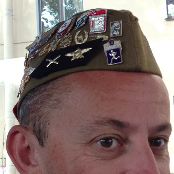 the man wearing the hat has a lot of pins on his head