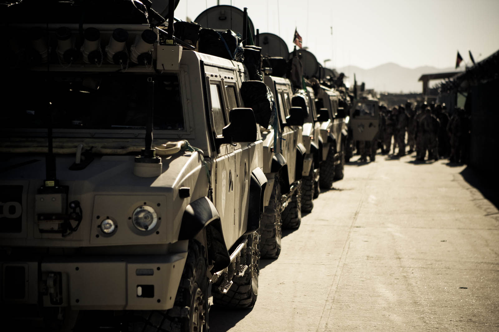 a row of military vehicles in the road