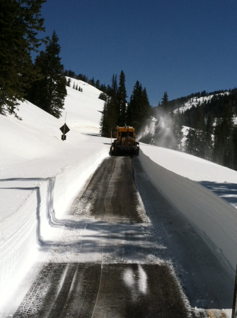 a construction truck driving down a road in the snow