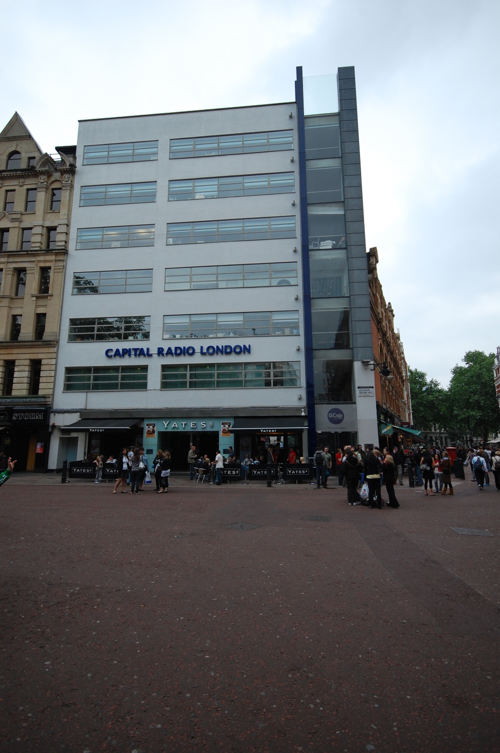 pedestrians are walking by a large white building