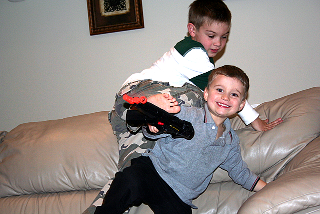 a boy sitting on the back of a little boy