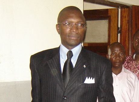 two women in dress clothes standing next to an african man