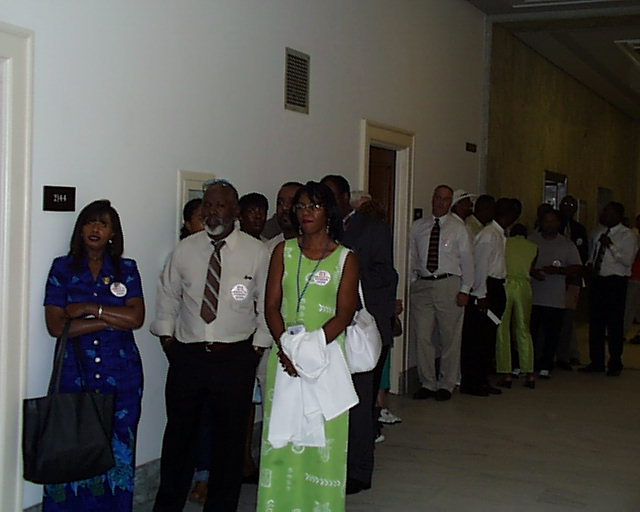 many people stand inside of a large building