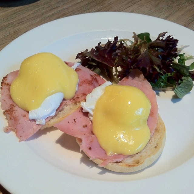 an english muffin topped with ham, cheese and eggs