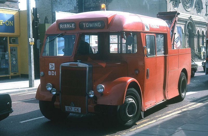 an old fashion red bus driving down the street