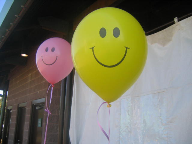 there are balloons with faces and the balloon is in the air