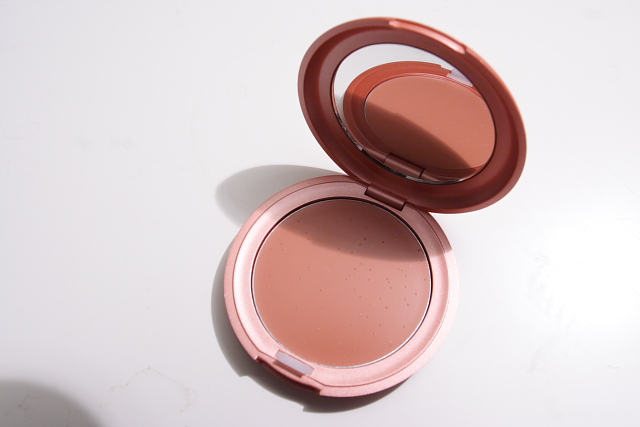 a powdered pressed on cheek with pink powder inside