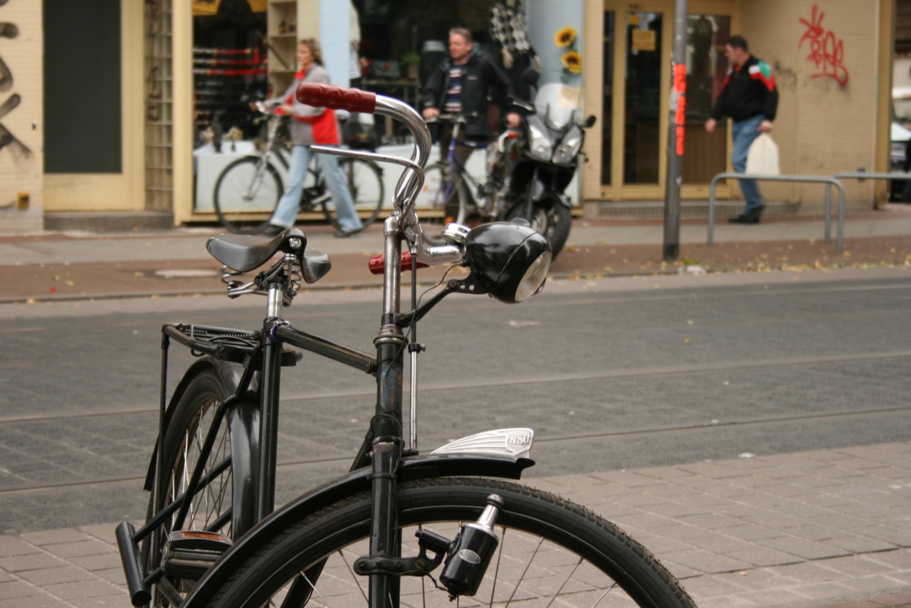 a bicycle parked on the street next to other bikes