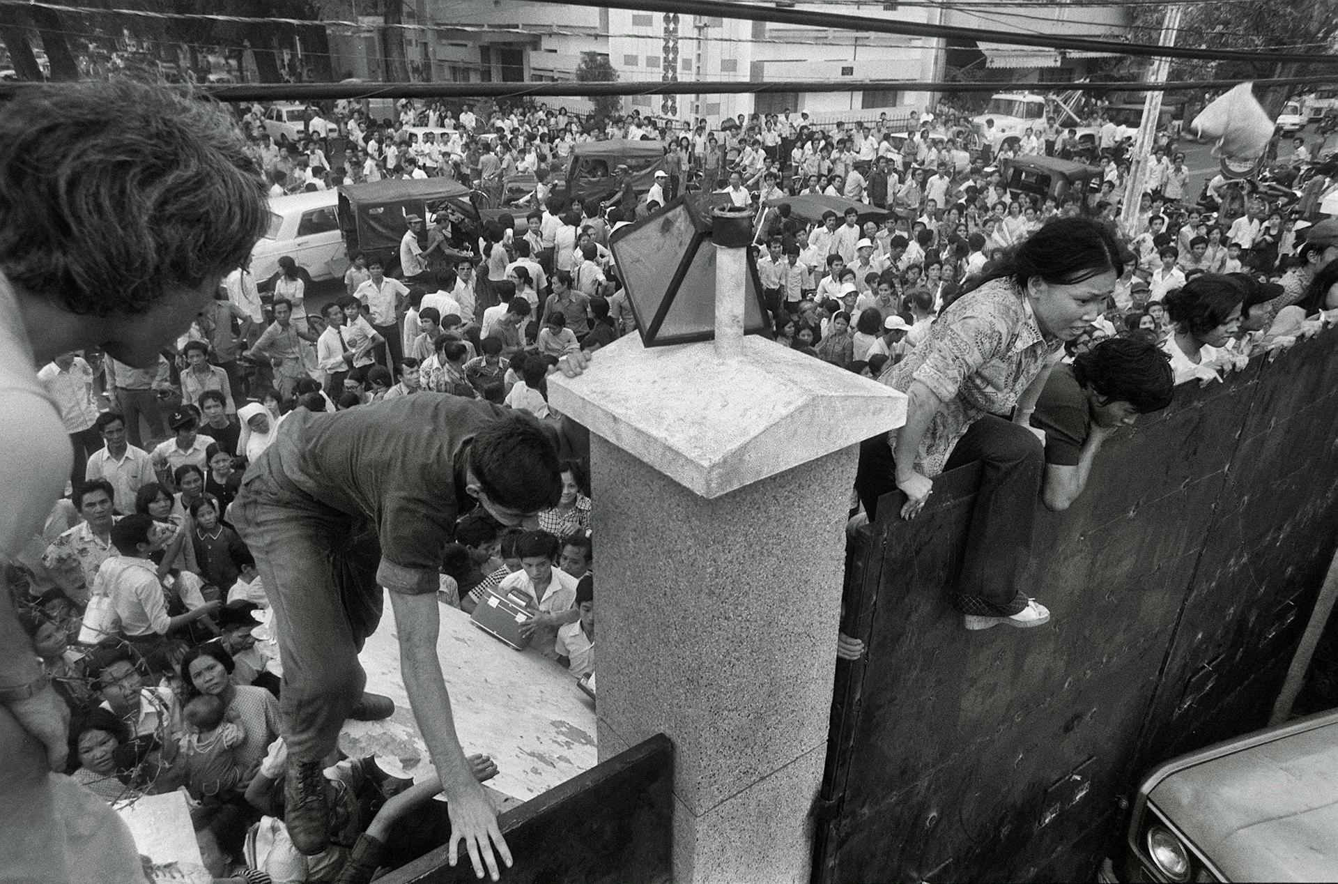 people standing around a large memorial in a crowded town square