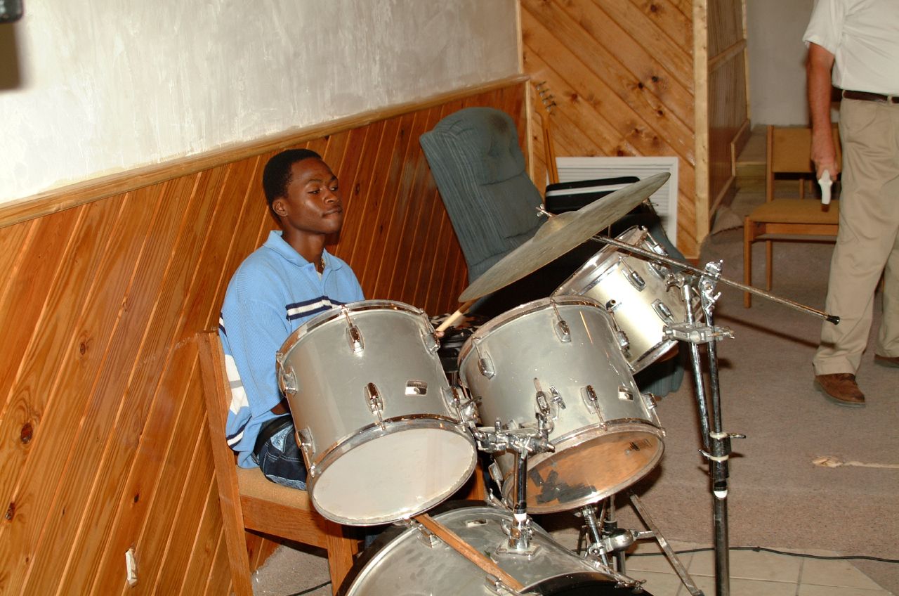 man with his legs up on the ground playing a music instrument