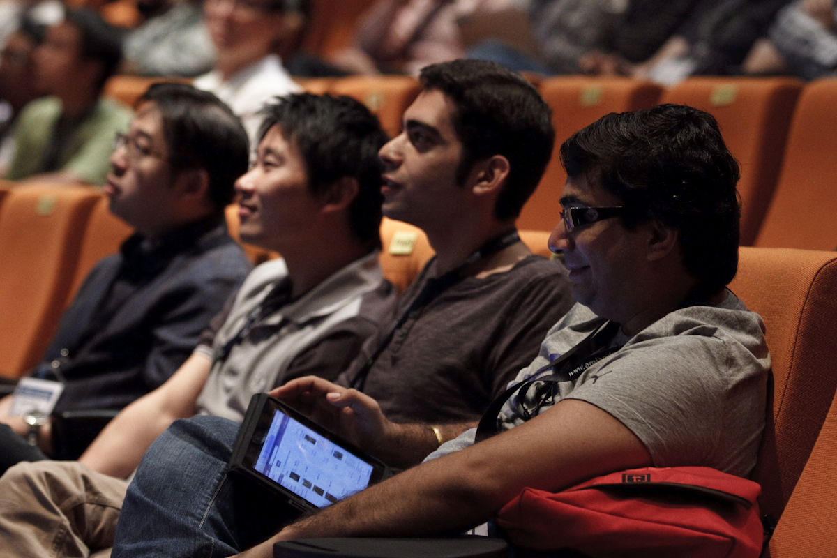 people are sitting in an auditorium and they have computers