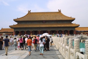 tourists visit the forbidden city gate with umbrellas