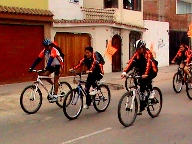 people on bicycle with helmets riding down the street