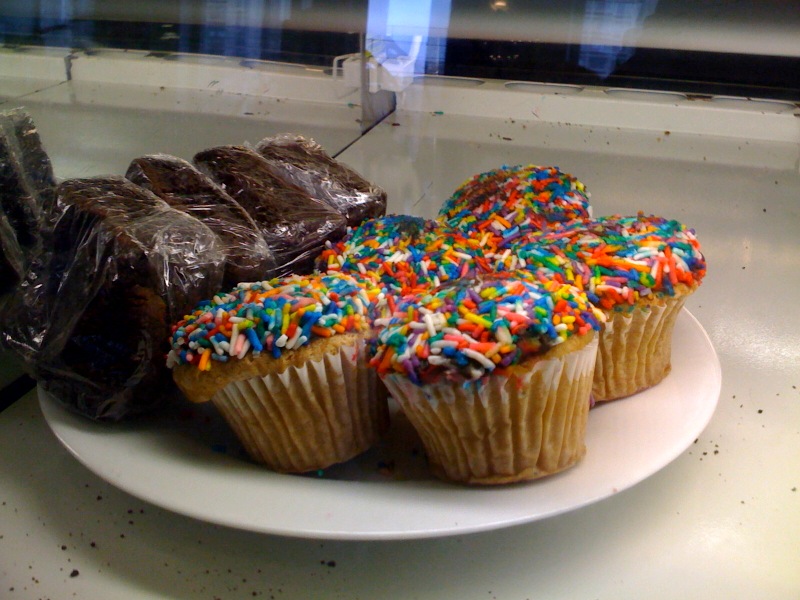 several large chocolate cupcakes sitting on a white plate