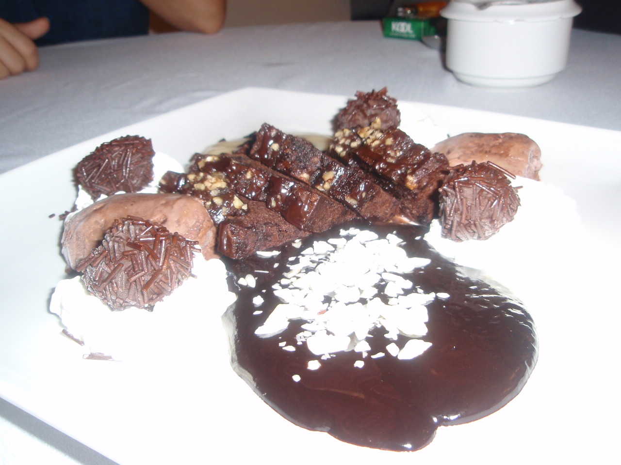 a square white plate holding a chocolate dessert