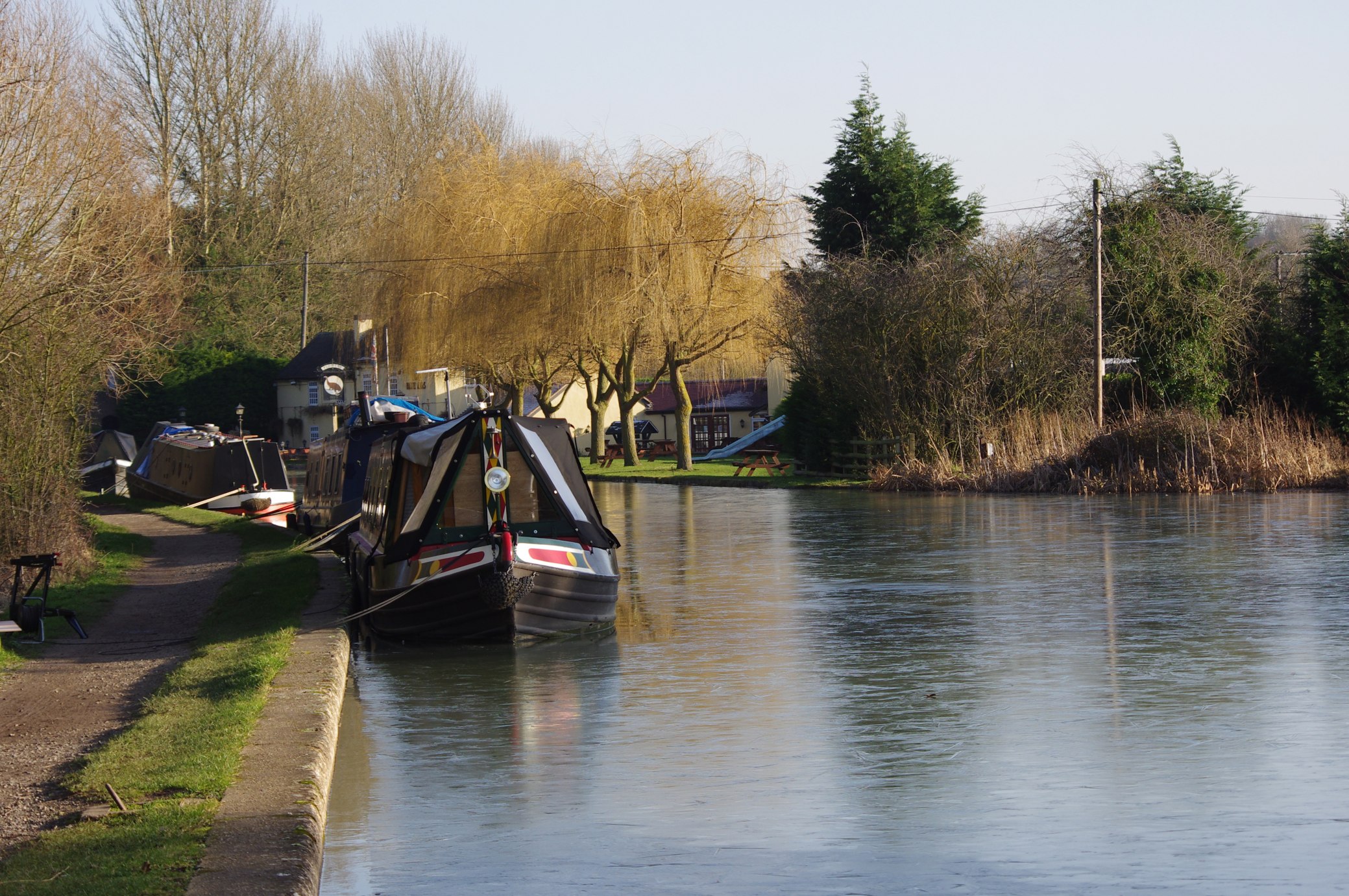 two narrow boats are docked in a canal