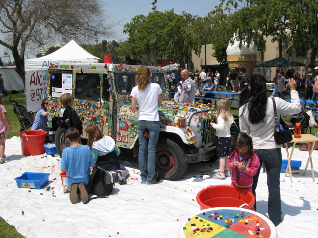 several people around a truck with various items on the back